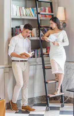 a man and a woman standing on a book shelf at U Sathorn Bangkok in Bangkok