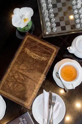 a table topped with a book and a cup of coffee at U Sathorn Bangkok in Bangkok