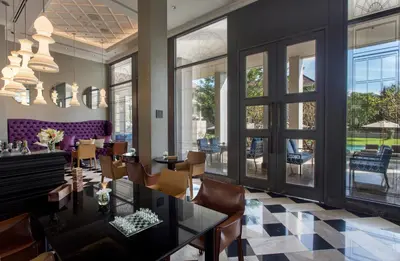 a dining room with a table and chairs and windows at U Sathorn Bangkok in Bangkok
