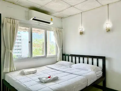 a bedroom with a bed with two towels on it at LSN Mansion in Bangkok