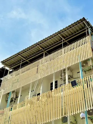 a white building with a bunch of wooden structures at LSN Mansion in Bangkok