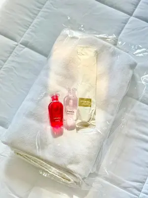 a plastic bag with a bottle and a red candle at LSN Mansion in Bangkok