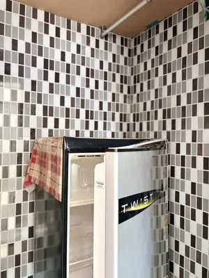 a refrigerator in a kitchen with black and white tiles at LSN Mansion in Bangkok
