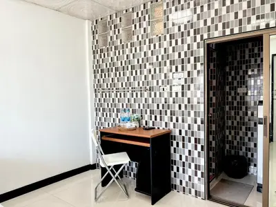 a room with a table with a chair and a tile wall at LSN Mansion in Bangkok