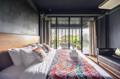 a bedroom with a bed with a laptop on it at MIQ Ekkamai2 3BR Designer home Oval Bathtub 15pax in Bangkok