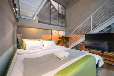 a bedroom with a large bed with a flat screen tv at MIQ Ekkamai2 3BR Designer home Oval Bathtub 15pax in Bangkok