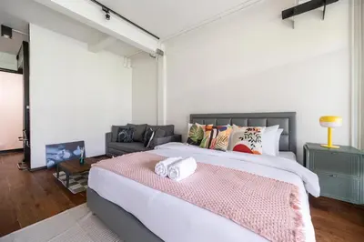 a bedroom with a large bed with a pink blanket at MIQ Ekkamai2 3BR Designer home Oval Bathtub 15pax in Bangkok