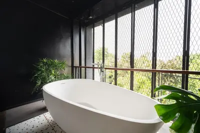 a white bath tub in a room with a window at MIQ Ekkamai2 3BR Designer home Oval Bathtub 15pax in Bangkok