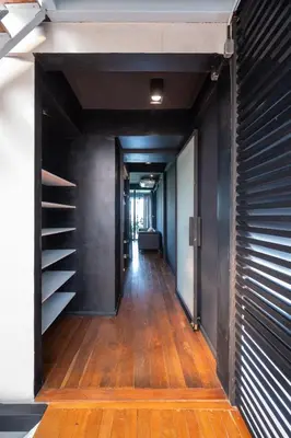 an empty hallway with black walls and wooden floors at MIQ Ekkamai2 3BR Designer home Oval Bathtub 15pax in Bangkok