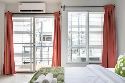 a bedroom with a bed and a large window at MIQ Ekkamai1 - 5BR house 65 inch TV in Bangkok