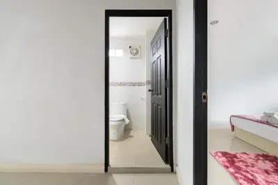 a bathroom with a toilet and a black door at MIQ Ekkamai1 - 5BR house 65 inch TV in Bangkok