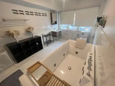 a large white bathroom with a tub and a table at 4 Bedroom House with Beautiful Rooftop near BTS Ekkamai in Bangkok