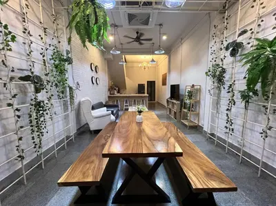 a wooden table in a room with plants on the walls at 4 Bedroom House with Beautiful Rooftop near BTS Ekkamai in Bangkok