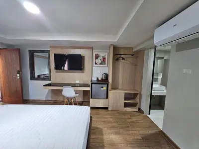 a bedroom with a bed and a kitchen with a sink at โรงแรมเซเว่นรัชดา S7VEN RATCHADA in Bangkok