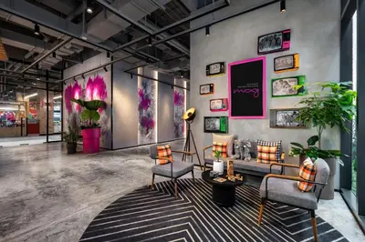 a room with chairs and paintings on the wall at Moxy Bangkok Ratchaprasong by Marriott in Bangkok