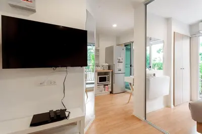 a living room with a large flat screen tv on a wall at Fully Furnished Studio Apartments in Bangkok