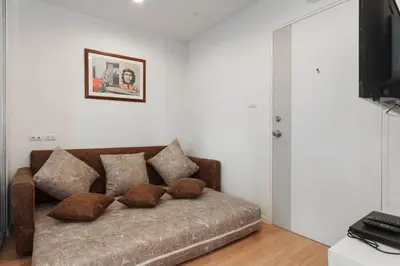 a couch with pillows on it in a living room at Fully Furnished Studio Apartments in Bangkok