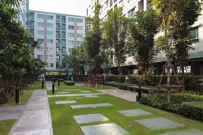 a park in front of a tall building at Fully Furnished Studio Apartments in Bangkok