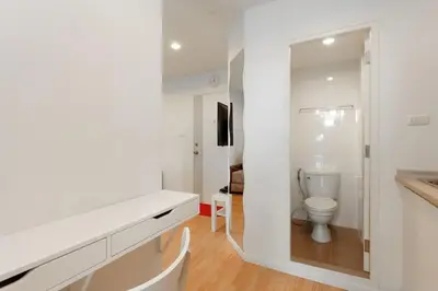 a white bathroom with a toilet and a mirror at Fully Furnished Studio Apartments in Bangkok