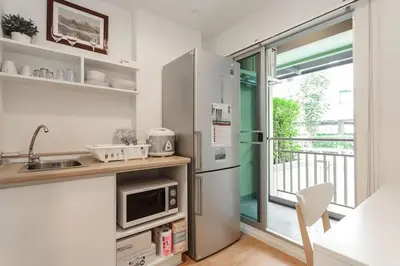 a kitchen with a stainless steel refrigerator and a window at Fully Furnished Studio Apartments in Bangkok