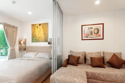 a bedroom with a bed and a couch at Fully Furnished Studio Apartments in Bangkok