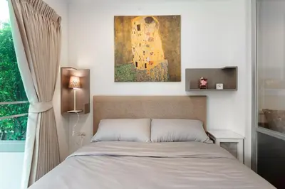 a bedroom with a bed and a painting on the wall at Fully Furnished Studio Apt. 110 in Bangkok