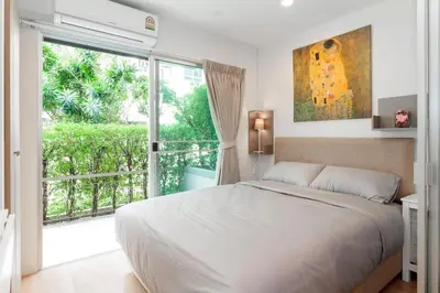 a bedroom with a large bed and a large window at Fully Furnished Studio Apt. 110 in Bangkok