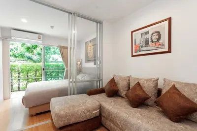 a living room with a couch and a bed at Fully Furnished Studio Apt. 110 in Bangkok