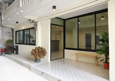 a facade of a building with a bench and plants at Chaiwat Hostel in Bangkok