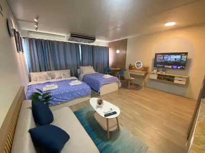 a living room with two beds and a tv at PTJ Style Condotel คอนโดเมืองทอง P1 in Ban Song Hong