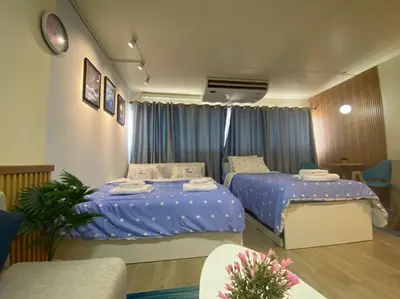 two beds in a room with blue sheets at PTJ Style Condotel คอนโดเมืองทอง P1 in Ban Song Hong