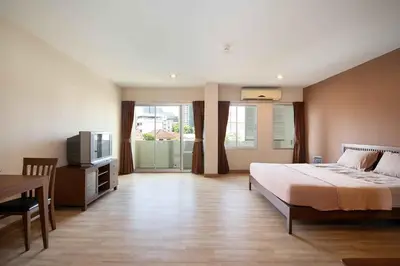 a bedroom with a bed and a tv and a table at 181 Ekkamai Apartment in Bangkok