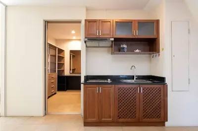 a kitchen with wooden cabinets and a sink at 181 Ekkamai Apartment in Bangkok