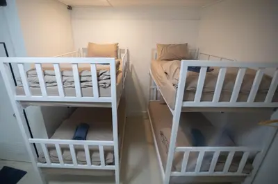 two white bunk beds in a small room at Bangkok Cozy Home @Khaosan Road in Bangkok
