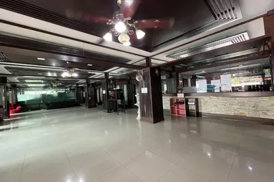 a large lobby with a tile floor and a ceiling at Phongsathon Mansion in Bangkok