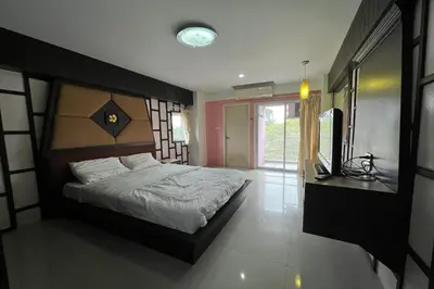 a bedroom with a large bed and a mirror at Phongsathon Mansion in Bangkok