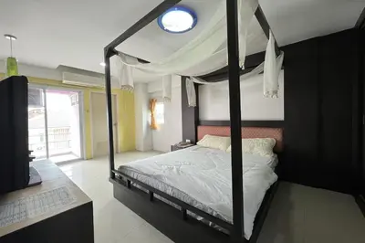 a bedroom with a canopy bed with a window at Phongsathon Mansion in Bangkok