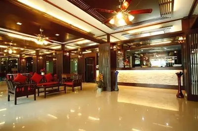 a lobby with a restaurant with red furniture and a bar at Phongsathon Mansion in Bangkok