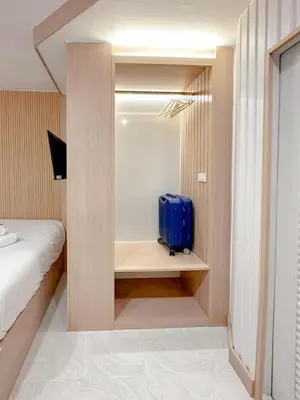 a suitcase sitting on a shelf in a bedroom at Thrive Hotel in Bangkok