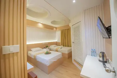 a hotel room with two beds and a television at Thrive Hotel in Bangkok