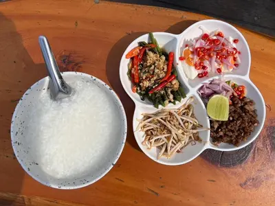 a table with two plates of food and a bowl of rice at Chainam-Charmchuree residences cafe and spa in Ban Bang Bua Thong