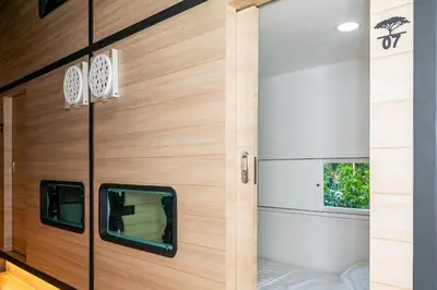 a wooden door with a window in a room at Chainam-Charmchuree residences cafe and spa in Ban Bang Bua Thong