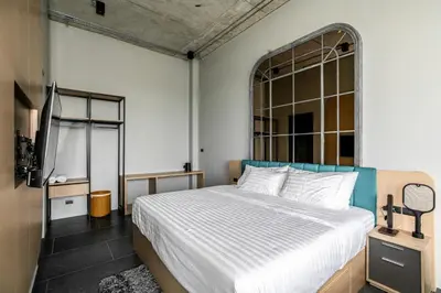 a bedroom with a bed and a large window at Chainam-Charmchuree residences cafe and spa in Ban Bang Bua Thong