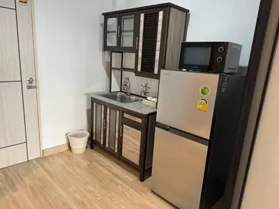 a small kitchen with a refrigerator and a sink at Pipp Residence in Bangkok
