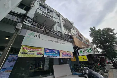 a building with signs on the side of it at Sukhum Huai Khwang Guest House in Bangkok
