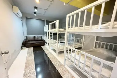 a room with several bunk beds and a couch at Sukhum Huai Khwang Guest House in Bangkok