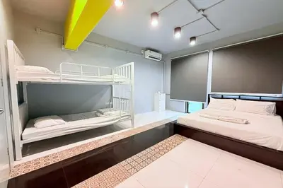 a bedroom with two bunk beds and a yellow ceiling at Sukhum Huai Khwang Guest House in Bangkok
