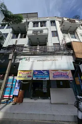 a white building with signs on the front of it at Sukhum Huai Khwang Guest House in Bangkok