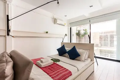 a bedroom with a large bed with blue and white pillows at MIQ_5br/Silom Bts,Mrt/Wifi 1000MB/Jacuzzi/16pax in Bangkok