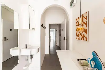 a white bathroom with a sink and a mirror at MIQ_5br/Silom Bts,Mrt/Wifi 1000MB/Jacuzzi/16pax in Bangkok